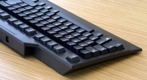 Tastiera di PC colore nero su scrivania in legno. Mycontract.it